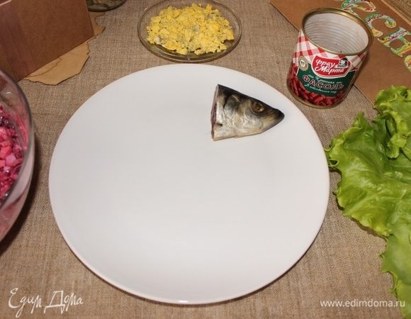 Часть салата сделаем в виде фрау сельди, выкладываем голову от сельди на тарелку.