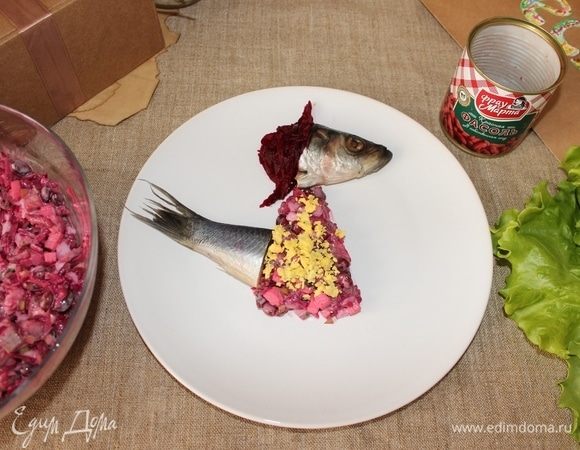 Затем из салата формируем платье и шляпку из свеклы, выкладываем хвост и декорируем платье желтком.