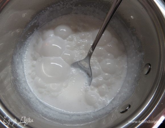 Во втором сотейнике соединяем сахар, воду и краситель (у меня базовый цвет белый, краситель диоксид титана), нагреваем до 110 °C и добавляем к молочной смеси, перемешиваем. Добавляем глюкозу и возвращаем сотейник на маленький огонь, мешаем до однородности. Убираем с огня и вводим желатин. Остужаем до 30 °C.