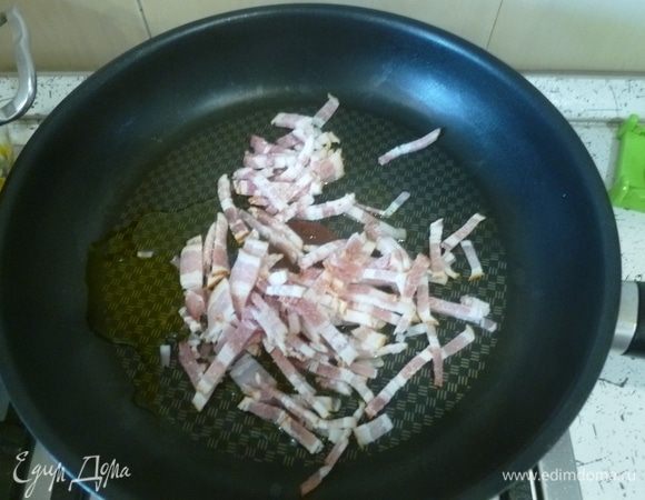 Бекон тонко нарезать, обжарить на оливковом масле на хорошо разогретой сковороде.