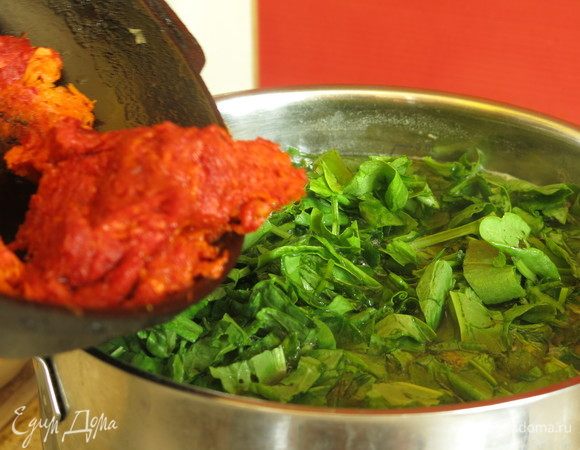 Кладем морковь с томатом. Нарезаем чеснок, кладем в борщ.