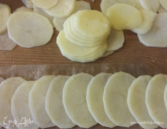 Для украшения несколько сырых картофелин тонко нарезаем и укладываем на бумагу.