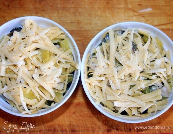 Выложить в керамические формочки, сверху посыпать натертым сыром.