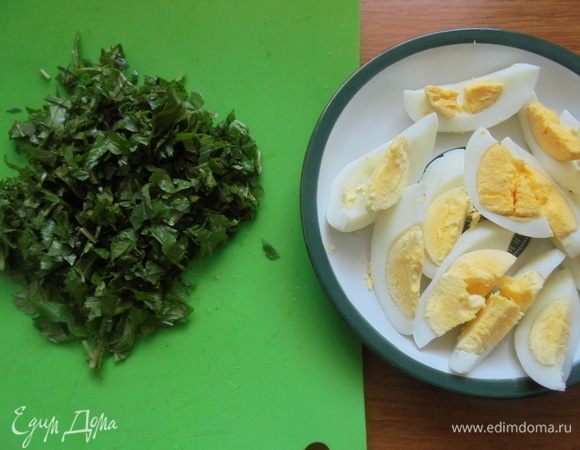 Очистите яйца от скорлупы и нарежьте дольками. Оставшуюся сныть промойте, обсушите и нарежьте для салата.