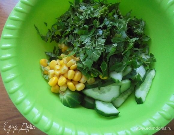 В миску выложить кукурузу, сныть, огурцы. Перемешать.
