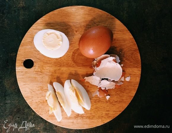 Остудить яйца, очистить от скорлупы и нарезать на дольки. Выкладываем в салатницу и добавляем слегка поджаренные кедровые орехи.