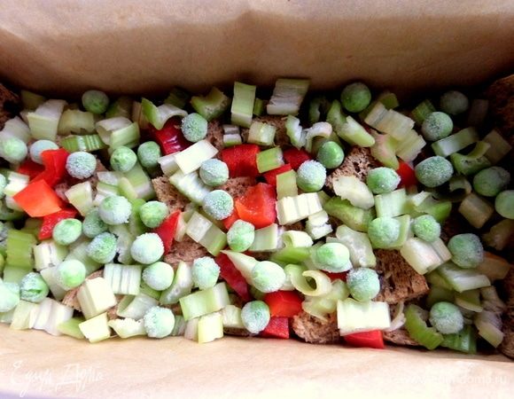 Насыпать половину овощей. Горошек прямо замороженный можно, да и консервированный вполне подойдет.