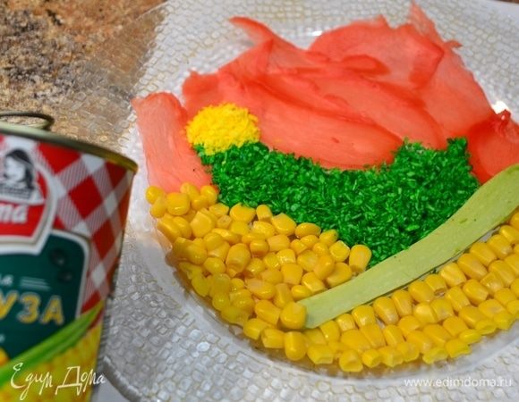 Я решила украсить верх салата как-то необычно. Вы можете этого не делать. Салат не потеряет своего вкуса. На блюдо выкладываю лепестки имбиря, кукурузу ТМ «Фрау Марта», пластинку от кабачка, стружку кокоса — желтую и зеленую. Сверху полить подготовленным желатином и отправить в холодильник застывать. Стараемся создать логотип «Фрау Марты»! :)