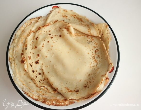 Раскалить чугунную сковороду, испечь блины с двух сторон, предварительно, перед выпечкой каждого блина, смазывать сковороду оливковым маслом. Готовые блины держать на водяной бане, пока вы жарите остальные блины. Пока они теплые, смазать топленым маслом.