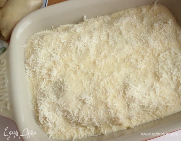 Посыпать пармезаном, натертым на мелкой терке. Отправить в духовку до образования румяной корочки. Это может занять 25–30 минут. Время приблизительное, ориентируйтесь на образование румяной корочки на поверхности, в то же время не передерживайте лазанью, чтобы не подгорело дно. Через 15 минут после начала выпечки огонь убавить до 180 °C.