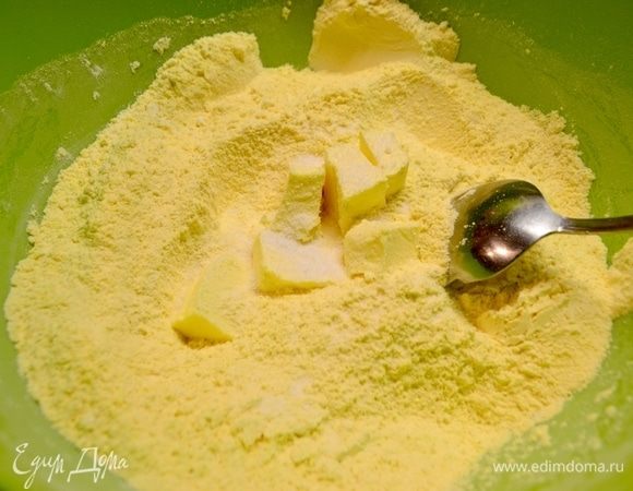 В миске соединить пшеничную и кукурузную муку, добавить соль и кусочек сливочного масла, размягченного до комнатной температуры.