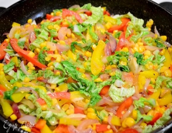 Обжарить слегка лук (нарезанный соломкой), перец красный и желтый (нарезанный соломкой), кукурузу, посолить, поперчить по вкусу. Добавить листья салата и выключить сковороду.