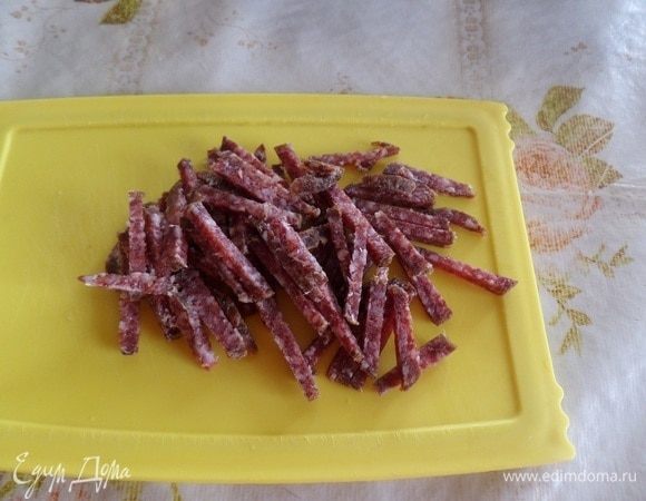 Соломкой нарезаем сырокопченую колбасу.