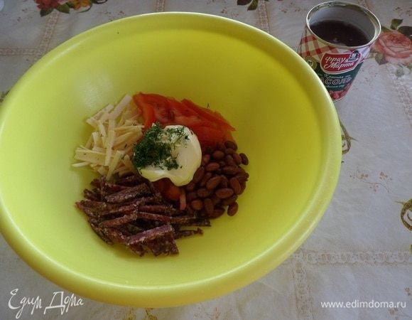 Фасоль ТМ «Фрау Марта» откидываем на дуршлаг. В чашку выкладываем фасоль, нарезанную колбасу, сыр, помидоры. Добавляем майонез, измельченный чеснок и зелень.