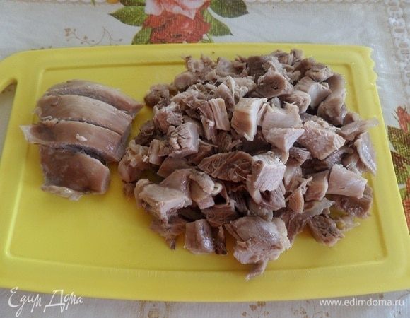 Отваренное куриное мясо вынимаем из кастрюли, слегка остужаем и нарезаем кубиком.