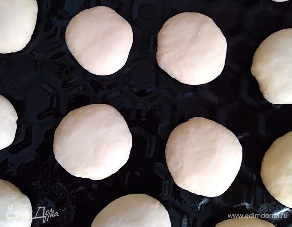 Противень смазать растительным маслом и поместить на него булочки швом вниз. Оставить на 45 минут на расстойку. Духовку разогреть до 180°C.