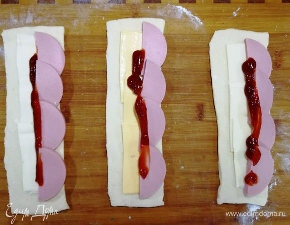 Укладываем полукольца вареной колбасы и кетчуп.