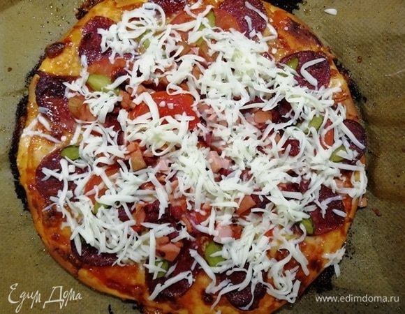 Вынимаем пиццу, посыпаем моцареллой и запекаем еще 2 минуты.