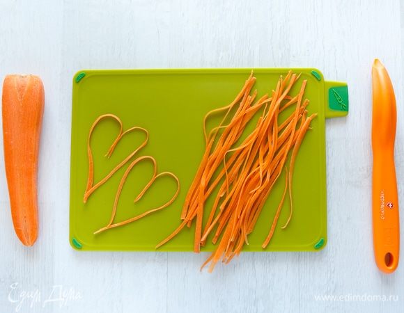 Морковь нарежем тоненькими полосочками сначала с помощью ножа для чистки овощей, а затем — обычным ножом.