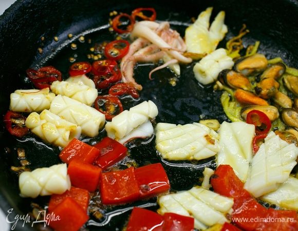 Здесь же быстро обжарим кусочки кальмаров, щупальца и мясо мидий (не больше 2–3 минут). Кальмары красиво свернутся в рулетики. Посолим, добавим сахар (2 ст. л.), а также соевый или другой соус, по вкусу и желанию.