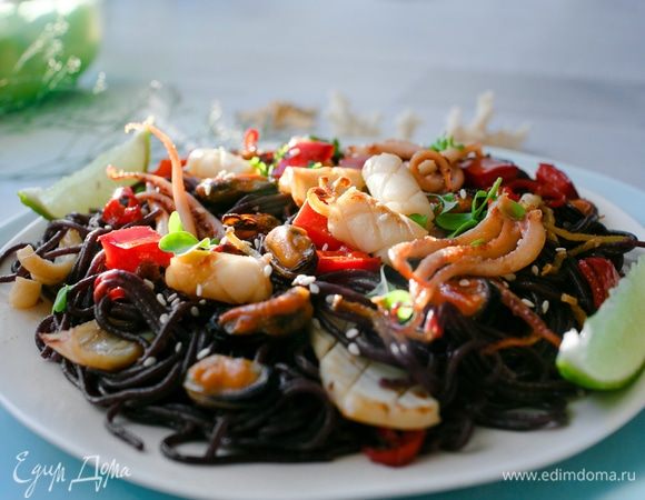 Выкладываем морепродукты с овощами на вермишель, посыпаем кунжутом, сбрызнем лаймом, украсим зеленью и подадим к столу.