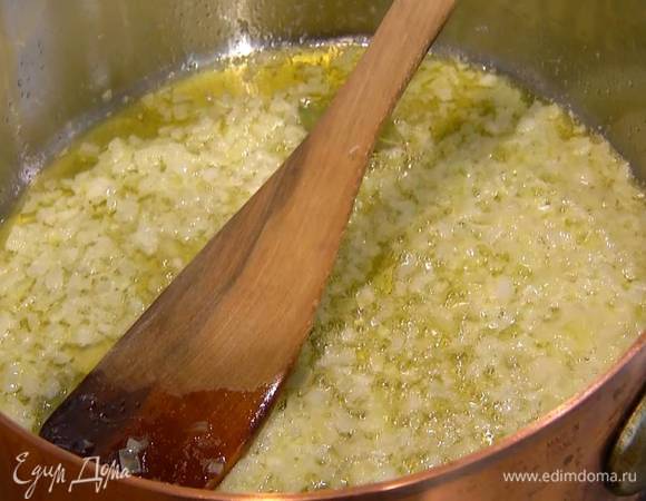 Разогреть в сотейнике с толстым дном 3 ст. ложки оливкового масла вместе со сливочным маслом и слегка обжарить лук, затем добавить чеснок, лавровые листья, перемешать и обжаривать лук до прозрачности.