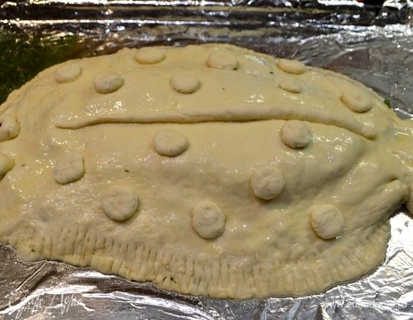 Накрываем пирог раскатанным тестом и защипываем по краям, можно придать, например, форму рыбы. У меня получилась веселая камбала–мультяшка:) Смазать яйцом. Отправляем в разогретую духовку при 190°C и выпекаем до готовности.