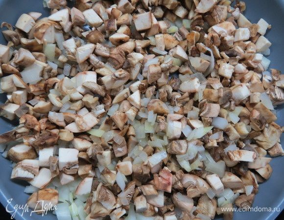 Грибы нарезать мелким кубиком, добавить в сковороду к луку, жарить до полуготовности 5 минут.