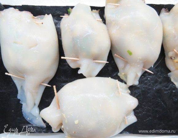 Выложить нафаршированные тушки кальмаров в глубокий противень или форму.