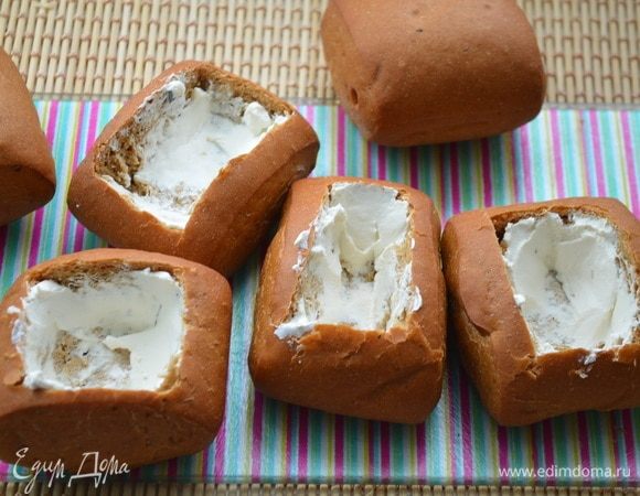 У булочек срезать верх и вынуть мякиш. Смазать изнутри каждую булочку творожным сыром.