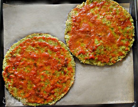Готовые коржи (2 шт.), выложите на противень, покрытый пекарской бумагой, смажьте коржи томатным соусом (у меня соус собственного приготовления с базиликом) по 3 ст. л. каждый.
