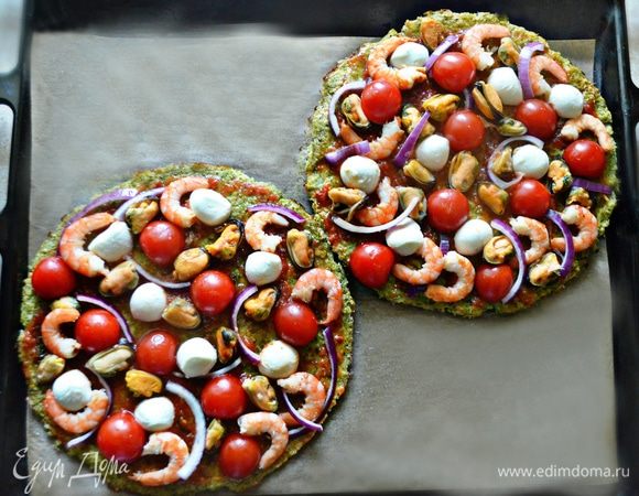 Выложите поверх коржей креветки и мидии, половинки черри, красный лук и моцареллу.