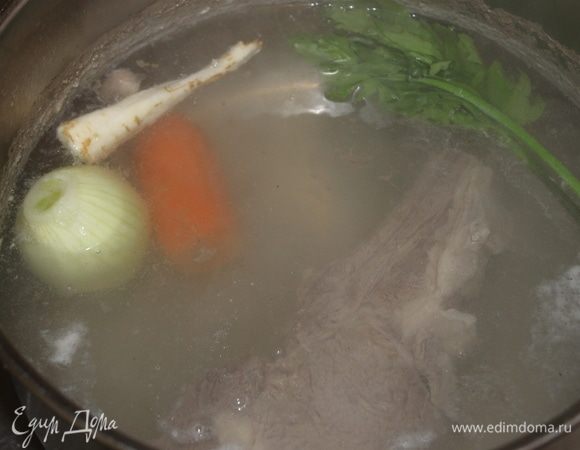 Мясо залейте 3 литрами воды, доведите до кипения, снимите пену и добавьте морковь, луковицу и тонкую часть от корня пастернака. Добавьте несколько веточек пряной зелени и варите бульон в течение двух часов на медленном огне. Бульон может быть приготовлен заранее и постоять в холодильнике пару дней. Бульон желательно процедить через мелкое сито.