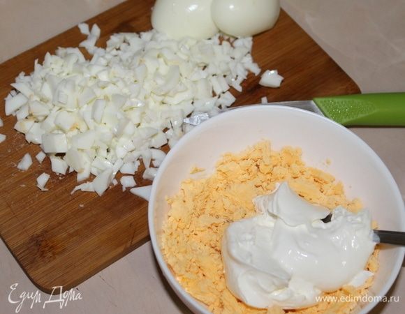 Подготовьте для борща заранее отваренные яйца. Белки мелко нарежьте, а желтки разомните вилкой, добавьте 2 ст. л. сметаны и перемешайте. У вас получится яичный соус.