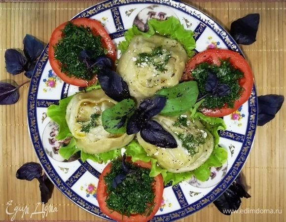 Подаем манты, полив сливочным маслом и украсив базиликом. Рядом выкладываем кольца помидора с гремолатой.