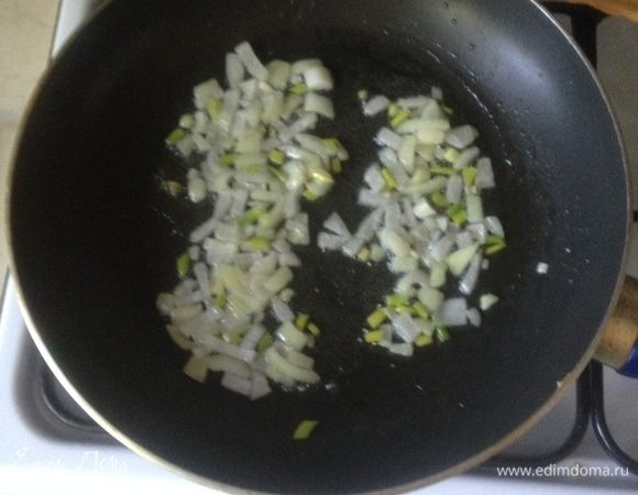 Пока варятся макароны, почистите и мелко нарежьте лук и чеснок. В сковороду налейте растительное масло и обжаривайте овощи на среднем огне до легкой золотистости.