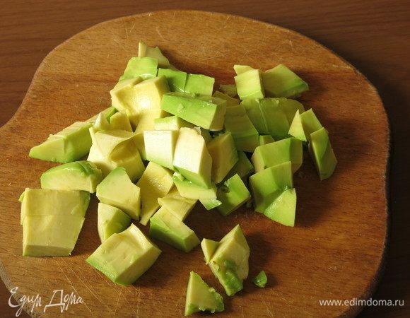 Нарезаем очищенное авокадо.