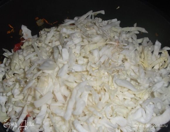 Нашинковать капусту и добавить к овощам. Тушить под крышкой до полуготовности капусты.