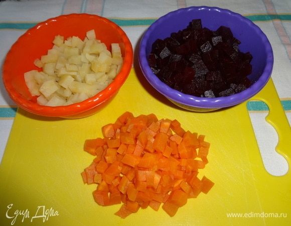 Свеклу, морковь, картофель очистить от кожуры и нарезать мелкими кубиками. Свеклу полить половиной нормы растительного масла и перемешать.