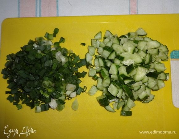 Огурцы нарезать мелкими кубиками. Зеленый лук мелко нарезать.