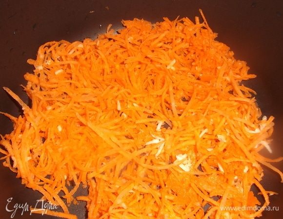 Крупную морковь натереть на терке вместе с чесноком. Половину выложить на дно посуды. Масло не добавлять.