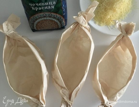 Ах да, чуть не забыла, «конвертики» из пергаментной бумаги. Тут тоже все просто. Сделала вот такие лодочки, концы скрутила, как у конфеты. Для подстраховки связала концы ниткой. Можно наполнять лодочки. И еще не забудьте натереть любого твердого сыра. В моем случае — пармезан для загорелой корочки (на заднем фоне).