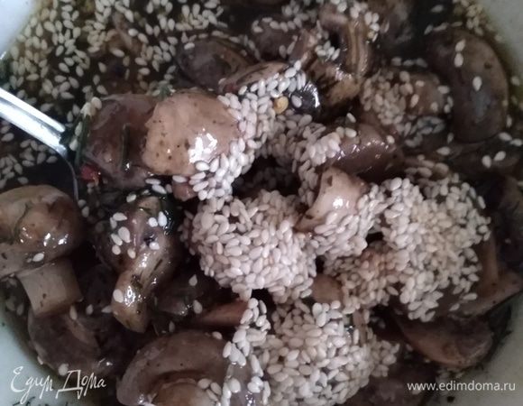 Грибы откинуть на дуршлаг, чтобы стекла вся вода. Перемешать с маринадом, всыпать кунжут, перемешать еще раз. После того, как грибы в маринаде остынут, накрыть пленкой или сразу переложить в банку с крышкой и убрать в холодильник на 12 часов.