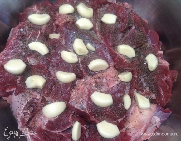 Две головки чеснока разбираем, чистим на зубчики и укладываем равномерно по мясу.