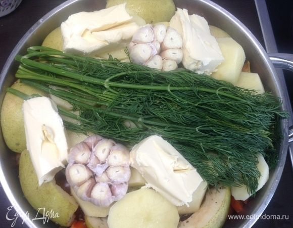 На баклажан — половинки картофелин, вторую половину масла сливочного кусочками, укроп свежий прямо сверху густой такой пучок. И пару целых головок чеснока (чуть помыв и верхний слой шелухи убрать, да корешки поцарапать ножом да помыть), я так у них чуть срезаю кончики зубчиков, так и соки-ароматы лучше уходят в блюдо, и потом на тарелке уже легче достается каждый зубчик.