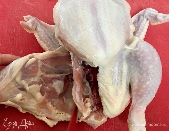 Отодвигаем куриное бедро и ножом прорезаем бедро от тушки в районе тазобедреннного сустава.