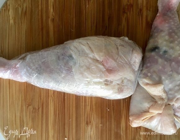 Фаршируем обе ножки. Лишнюю кожу можно или срезать, или, как я, аккуратно у основания заколола зубочистками. Теперь ножки можно запекать. А вот для того, чтобы ножки вертикально стояли, как на фото, необходимо провести с ними такие манипуляции. Каждую ножку сперва туго обмотать пищевой пленкой, не захватывая нижний сустав.