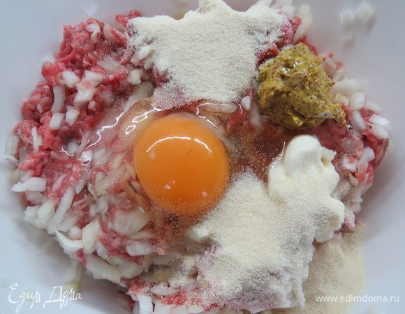 В фарш добавить манку, горчицу, майонез, соль, свежемолотый перец и яйцо, перемешать до однородной массы и оставить минут на 30 и более, чтобы манка набухла, и масса стала пышной.