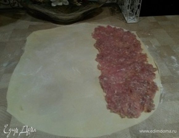 Фарш достаньте из холодильника, добавьте 50 мл молока и перемешайте. Молоко добавляем для сочности фарша. Выложите на половину теста фарш тонким слоем.
