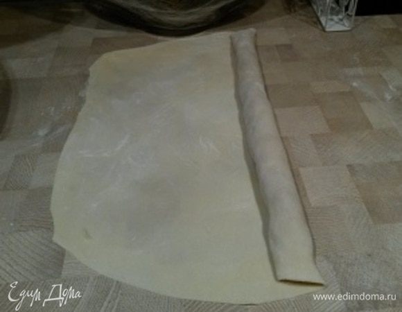 Скрутите рулет и отрежьте лишнее тесто. Позже на отрезанную часть теста мы также будем выкладывать фарш.